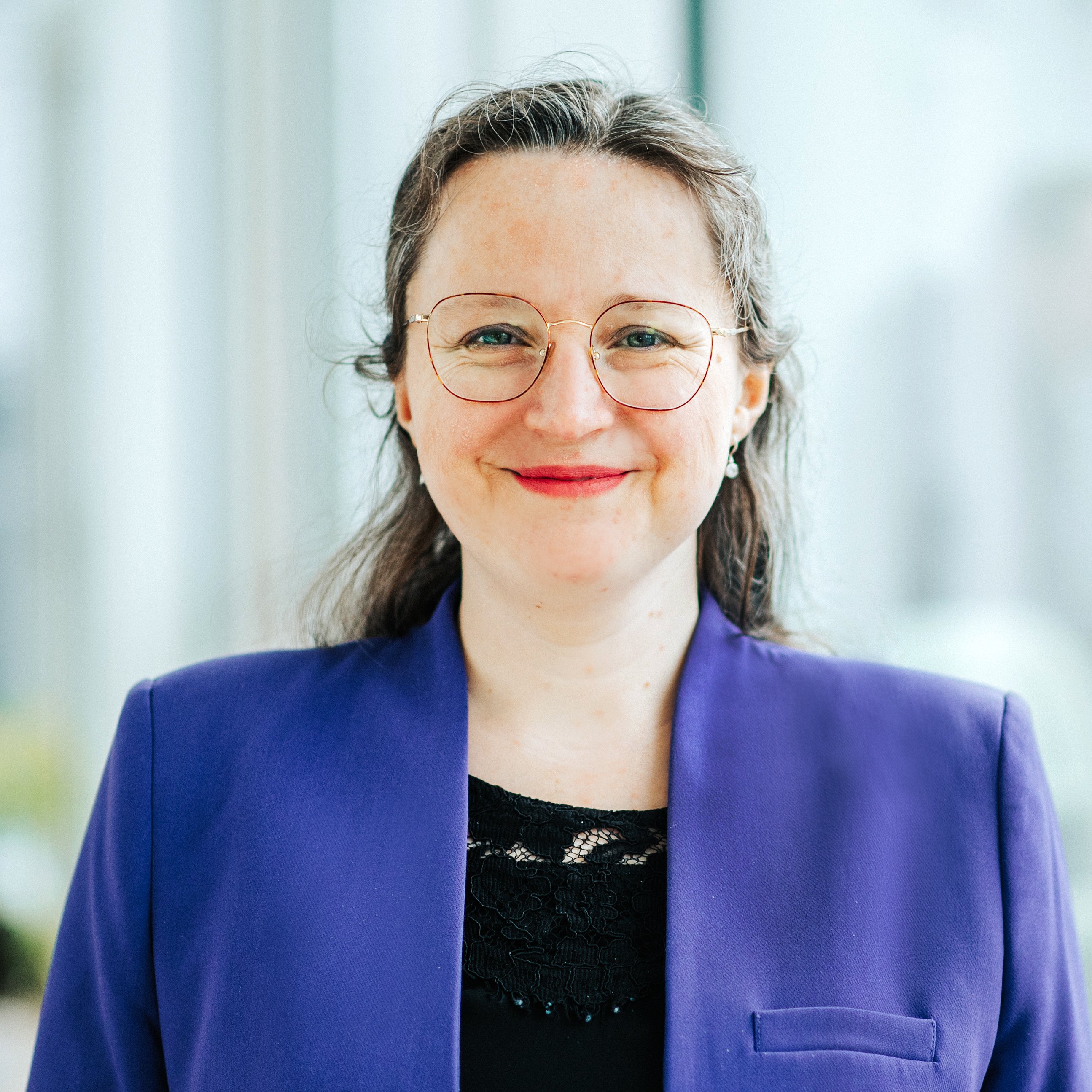 Dr. Eva-Maria Obermann aus dem Venueless-Team. Eva trögt einen violetten Blazer und lächelt in die Kamera.